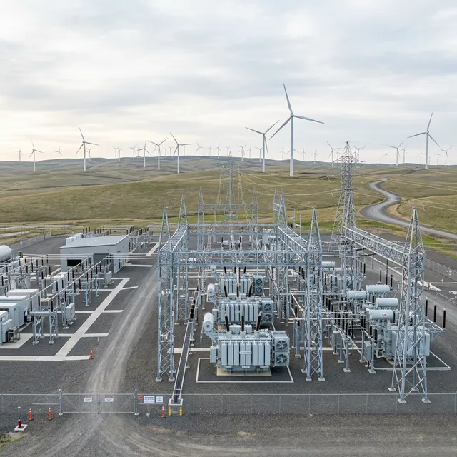 Modern electrical substation situated near a large-scale wind farm